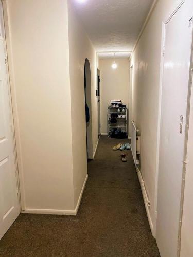 a long hallway with a room with white walls at Comfortable double bedroom in London in Hornchurch