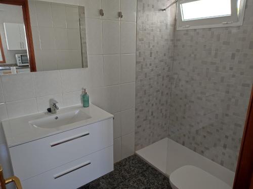 a white bathroom with a sink and a shower at Casa Luisi in Playa Honda