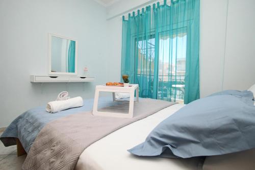 a bedroom with a bed and a table with a mirror at Blue Deluxe Apartment in Kallithea Halkidikis