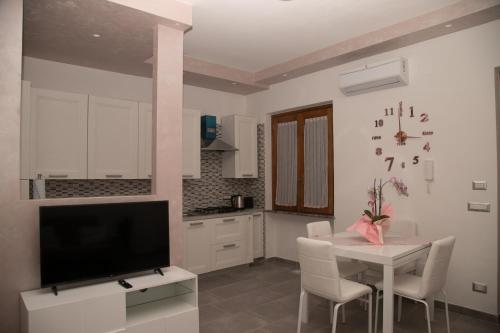 a kitchen with a table and a tv and a dining room at Il Violino degli Dei Holiday House in Agerola