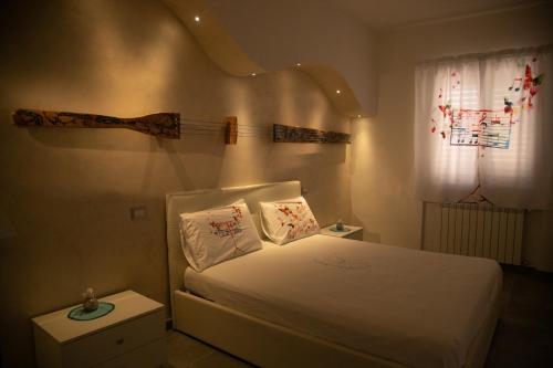 a bedroom with a bed with a branch on the wall at Il Violino degli Dei Holiday House in Agerola