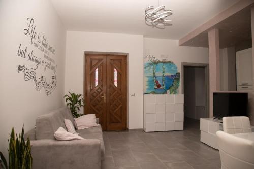 a living room with a couch and a wooden door at Il Violino degli Dei Holiday House in Agerola