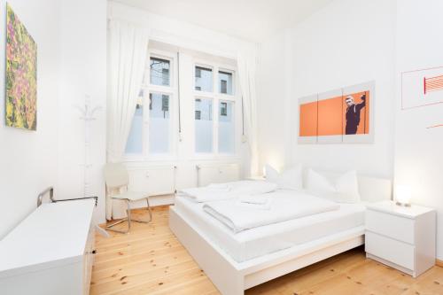 ein weißes Schlafzimmer mit einem weißen Bett und einem Fenster in der Unterkunft Apartment Berlin Zentrum in Berlin