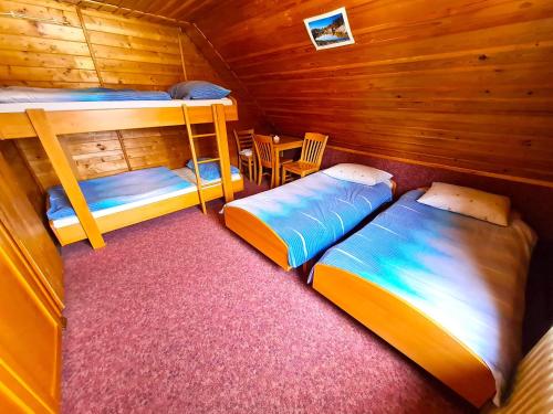a bedroom with two bunk beds and a table at Chalet Zala at Vogel mountain - cable car access or hiking - not reachable with car in Ukanc