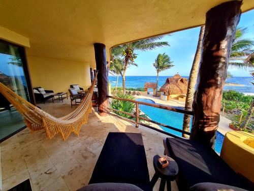 a room with a hammock and a view of the ocean at STYLISH OCEANFRONT CONDO with POOL in Mahahual