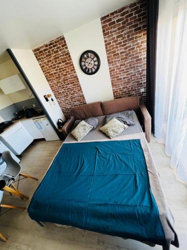 une chambre avec un lit et un mur de briques dans l'établissement Appartement ds résidence privée avec piscine à 5 min à pied plage!!, à Cannes