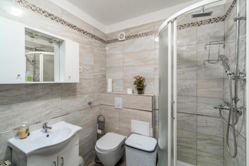 ein Badezimmer mit Dusche, Toilette und Waschbecken in der Unterkunft Dijamant Apartment in Split