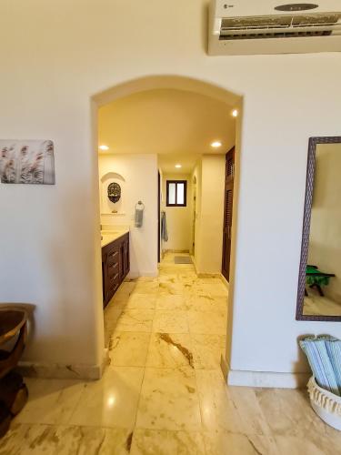 a hallway of a kitchen with a tile floor at STYLISH OCEANFRONT CONDO with POOL in Mahahual