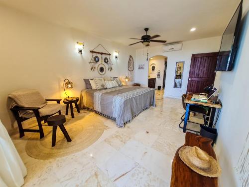 a bedroom with a bed and a table and a chair at STYLISH OCEANFRONT CONDO with POOL in Mahahual