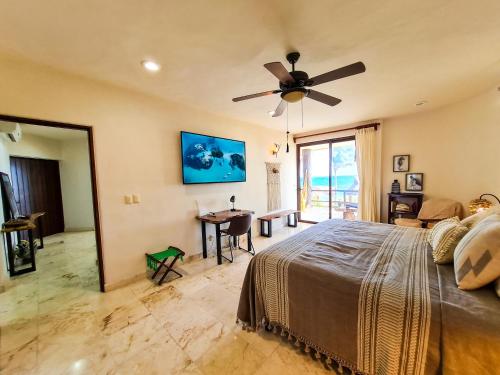 a bedroom with a bed and a ceiling fan at STYLISH OCEANFRONT CONDO with POOL in Mahahual