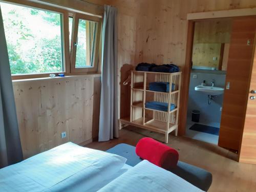 a bedroom with a bed and a sink and a window at Chalet Muehlwiese in Lindberg