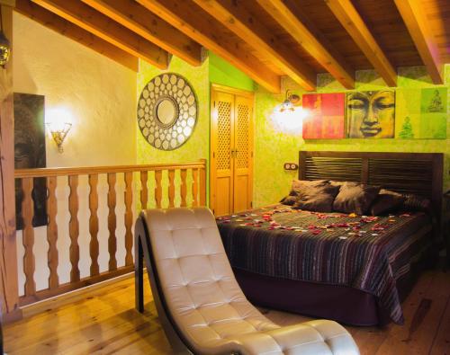 a bedroom with a bed and a chair in it at Suite Love in Gilgarcía
