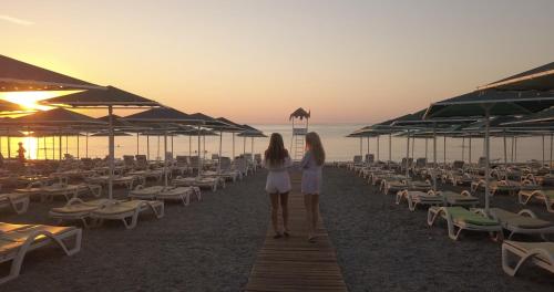 two girls standing on the beach watching the sunset at Camyuva Beach Hotel in Kemer