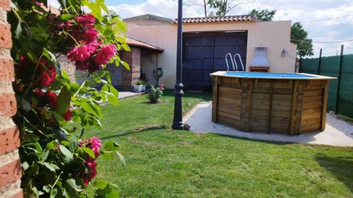 a backyard with a hot tub in the grass at Casa Rural Mudayyan in Coca de Alba