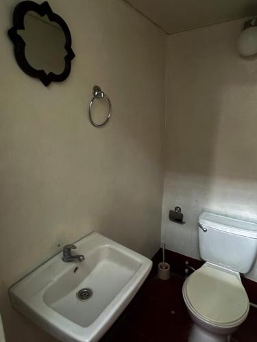 a bathroom with a white toilet and a sink at Hostal tortuga viajera in Moyogalpa