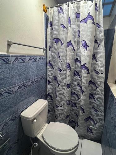 a bathroom with a toilet and a shower curtain at Hostal tortuga viajera in Moyogalpa