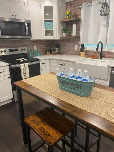 a kitchen with a table with a container of water at Cozy 2-bedroom Farmhouse with parking on premise in Smyrna