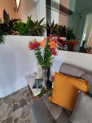 a living room with a couch and a table with flowers at Hotel Barbiani in Riccione