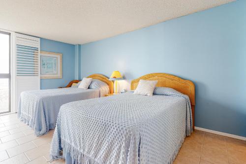 Dos camas en una habitación con paredes azules. en Sea Colony --- 401 Dover House, en Bethany Beach