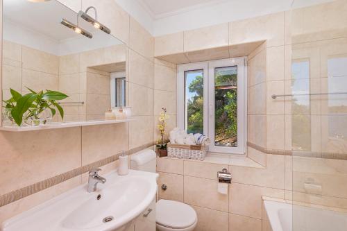 a bathroom with a sink toilet and a window at Apartments Daniela & Karlo in Sobra