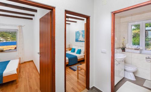 pokój z dwoma łóżkami i łazienką z toaletą w obiekcie Apartments Daniela & Karlo w mieście Sobra