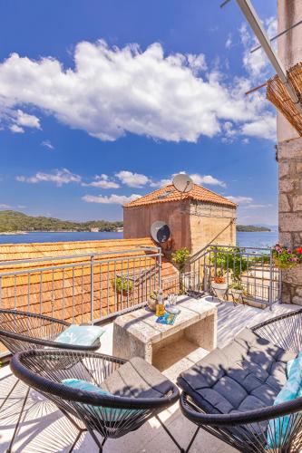 a patio with chairs and a table and a building at Apartments Daniela & Karlo in Sobra