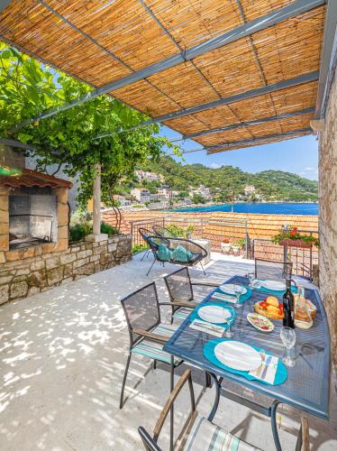 a patio with a table and chairs with a view of the water at Apartments Daniela & Karlo in Sobra