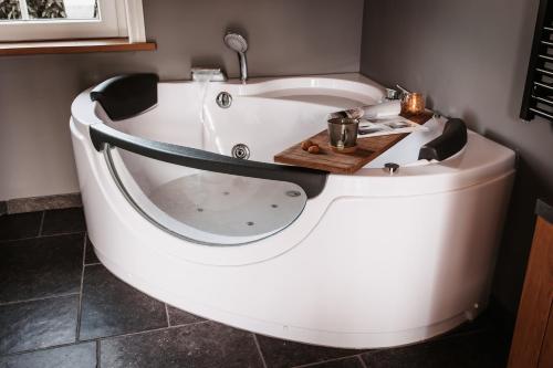 een groot wit bad in de badkamer bij -NIEUW- Luxe & sfeervol Vakantiehuis Tholen in Tholen