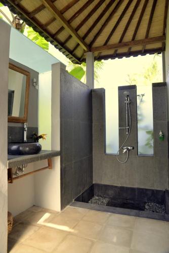 a bathroom with a shower and a sink at Prashanti Bali in Ubud