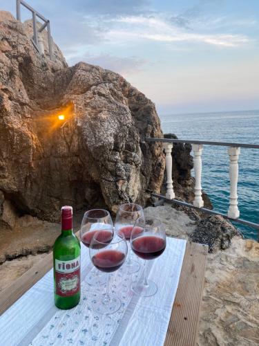 two glasses of wine sitting on a table near the ocean at ZBB Stylish Villa & Bungalows in Alanya
