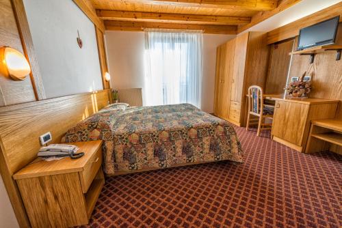 une chambre d'hôtel avec un lit et une table dans l'établissement La Montanina Hotel in Val di Non, à Malosco