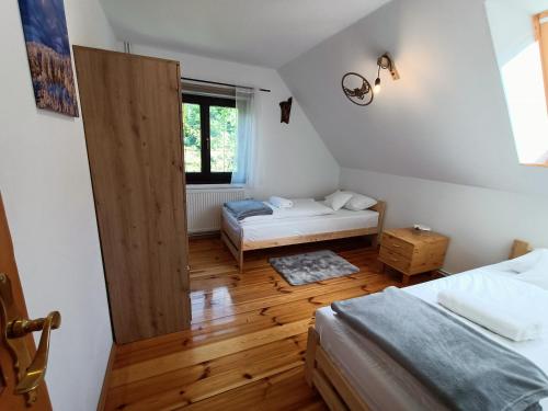 um pequeno quarto com 2 camas e uma janela em Dom nad Potokiem Sowa em Rzeczka