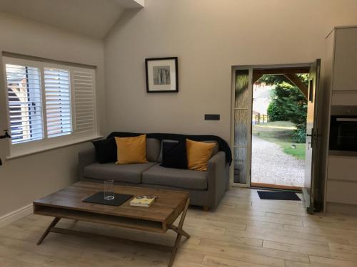 a living room with a couch and a coffee table at Cosy cottage in the heart of the Cotswolds in Cirencester