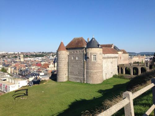 a castle on a hill with a city in the background at Studio Les pieds dans l'eau in Dieppe