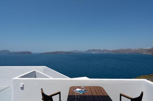 a table and chairs on a balcony overlooking the ocean at Hotel Goulielmos in Akrotiri