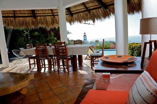 a dining room with a table and chairs and the ocean at Villa Casa Blanca del Faro in Zipolite