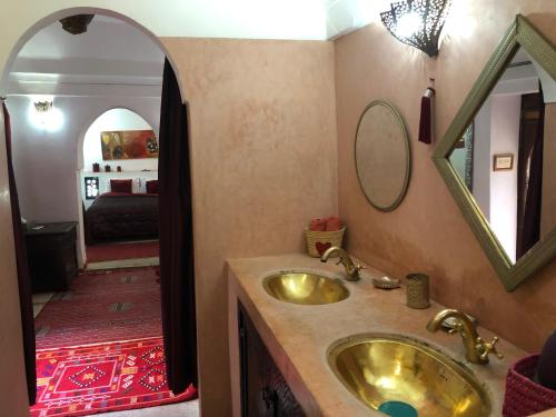 La salle de bains est pourvue d'un lavabo en or et d'un miroir. dans l'établissement Riad Alamine, à Marrakech