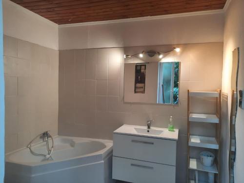 uma casa de banho com uma banheira e um lavatório e uma banheira em Jc 15 em San-Martino-di-Lota