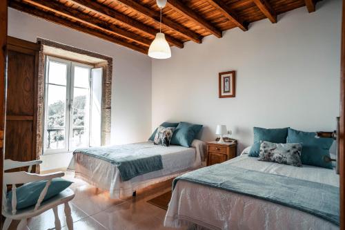 1 dormitorio con 2 camas y ventana en Casa en Muros con preciosas vistas al mar, en Muros