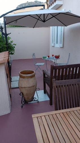 a patio with a vase and a table and an umbrella at Lumera in Santa Flavia