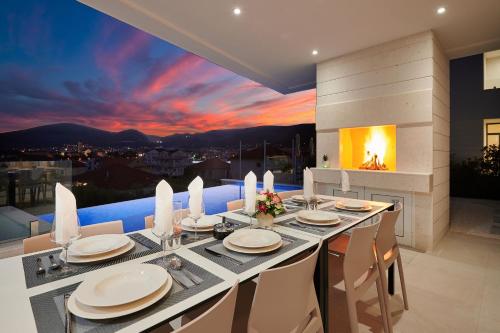 a dining room with a table and a fireplace at Villa Trogir 2 in Trogir
