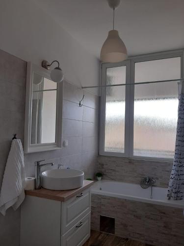 a bathroom with a sink and a tub and a window at Elegant Inn Gospić in Gospić