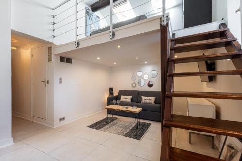a loft apartment with a staircase and a couch at Superbe appartement en plein centre du vieil Antibes in Antibes