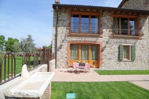 a stone house with a table and chairs on a patio at Residence Borgo Mondragon in Lazise