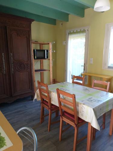 une cuisine avec une table et des chaises et un micro-ondes dans l'établissement Charmant logement calme de 35 m2, parking gratuit, à Folligny