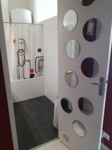 ein Badezimmer mit Dusche und runden Spiegeln in der Unterkunft Studio Terrasse Proche Palais des Festivals in Cannes