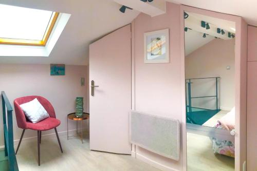 a room with a bed and a chair and a window at Charming townhouse with garden in the City of Love in Paris