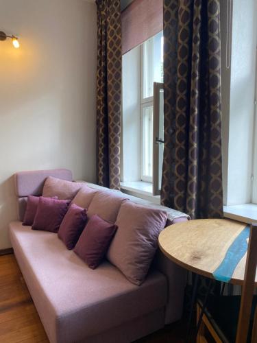 a couch with purple pillows sitting next to a table at Poe Luxury in Tartu
