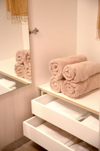a bathroom with white shelves with towels on them at Nikogroup By the Sea 3 in Polychrono
