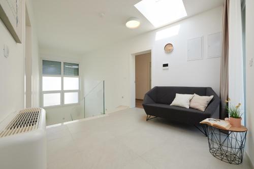 a living room with a black couch and a window at Villa Trogir 2 in Trogir